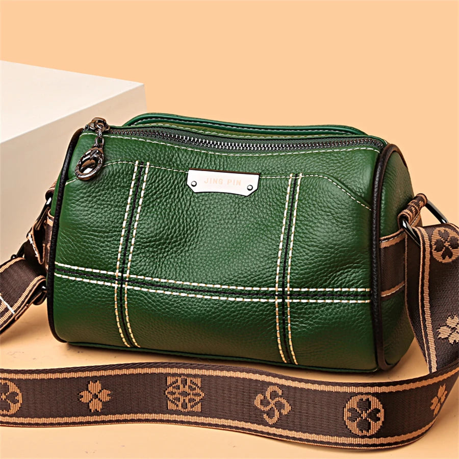 A dark green vintage genuine leather women's shoulder bag with brown leather strap and stitching.