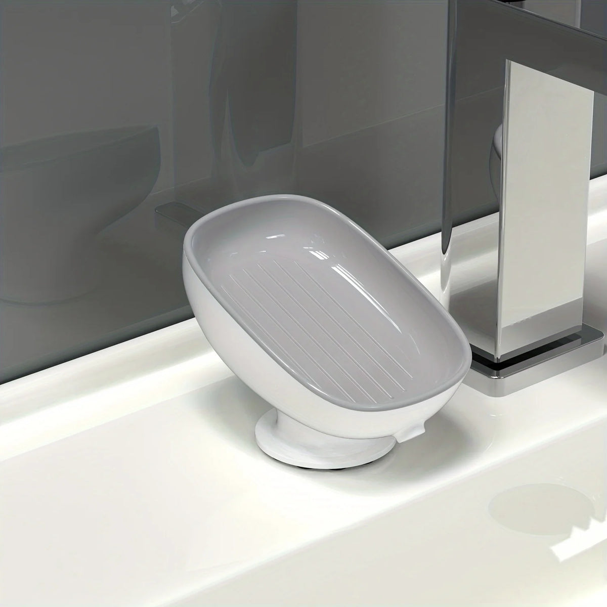 A white, leaf-shaped suction cup soap dish is placed on a white bathroom sink.