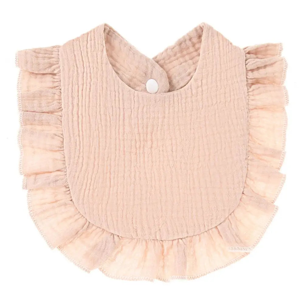 A light pink, textured cotton baby bib in a bandana style with ruffled edges.