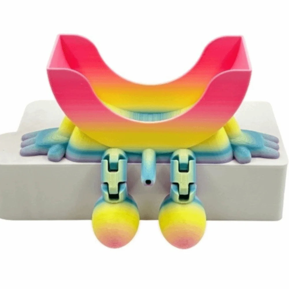 A pink and yellow 3D sponge holder with a hanging design for the kitchen sink.