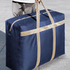A navy blue waterproof moving and storage bag with tan straps is being held by a person.