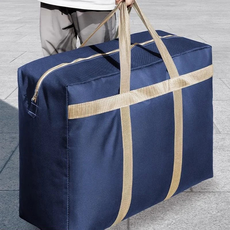 A navy blue waterproof moving and storage bag with tan straps is being held by a person.