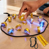 A hand is placing magnetic strategy game pieces, shaped like polyhedrons, onto a black elastic band on a wooden surface.