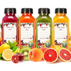 A collection of twenty juice bottles in various colors like red, orange, and green, surrounded by fresh fruit.