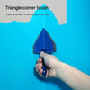 A hand is using a triangle corner brush to paint a blue wall, demonstrating how there is no leak in the corner.
