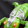 A green gecko toy with silver armor and glowing red LED eyes is shown against a dark background.