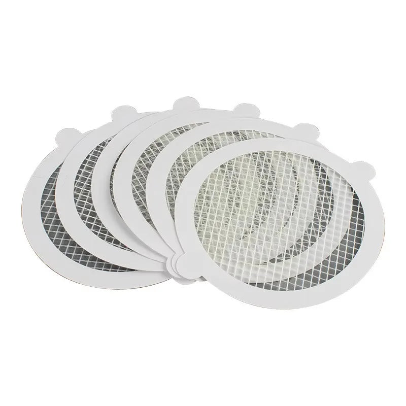 A stack of white mesh filters used as disposable shower drain hair catchers for sinks and floor drains.