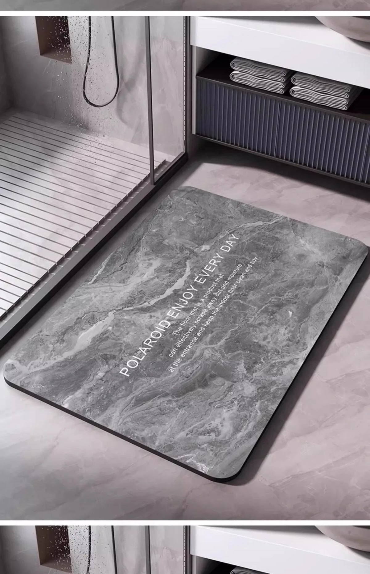 A gray marble-look non-slip bathroom mat is placed on a light-colored floor next to a shower area.