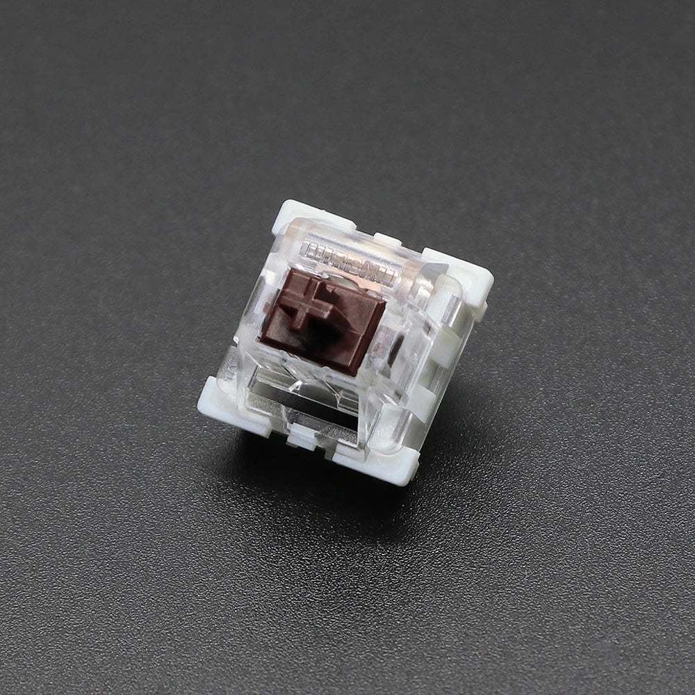 A close-up view of a white mechanical keyboard switch housing with a brown plastic stem.