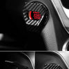 Close-up of a carbon fiber engine start stop button cover installed on a car interior panel.