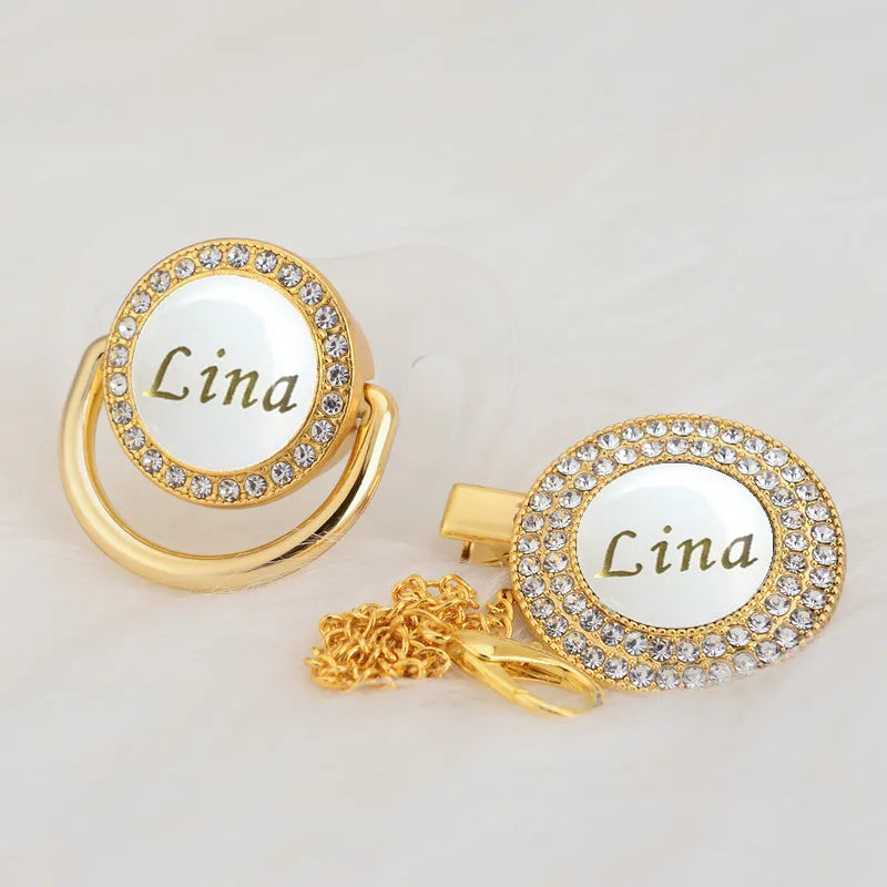 Gold-toned ring with a white oval center engraved with the name Lina and surrounded by clear rhinestones