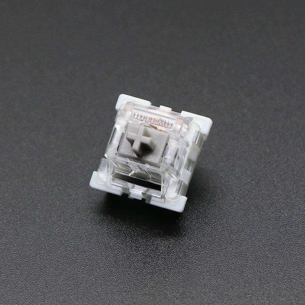 A close-up view of a white Outemu mechanical keyboard switch housing.