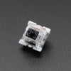 A close-up view of a white mechanical keyboard switch housing with a black plastic stem.