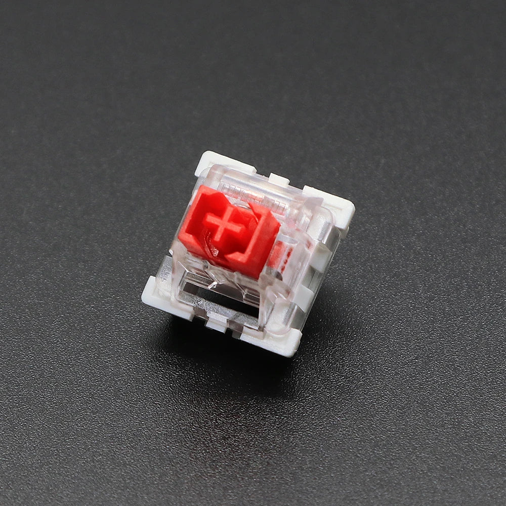 A close-up view of a red Outemu mechanical keyboard switch, a 3-pin component used in keyboards.