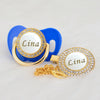 Gold and blue rhinestone pacifier featuring the name Lina on a circular disc