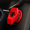 A close-up of a red aluminum alloy engine start button cover on a dark panel.