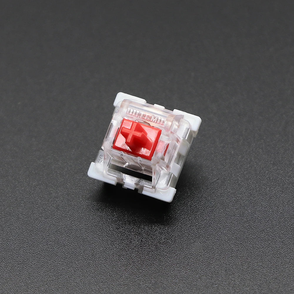 A close-up view of a red Outemu mechanical keyboard switch with a white housing and visible text.