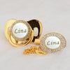 Gold rhinestone pacifier featuring the name Lina on a white disc and clip.
