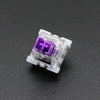 A close-up view of a white Outemu mechanical keyboard switch with a purple housing and plastic pins.