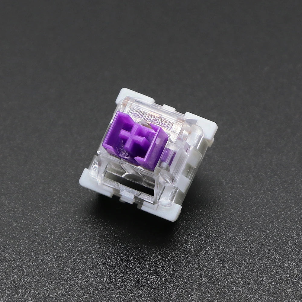 A close-up view of a white Outemu mechanical keyboard switch with a purple housing and plastic pins.