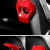 Close-up of a red engine start stop button cover on a black car interior panel.