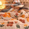 A woman is relaxing in a bed covered with a cozy double-sided velvet warm quilt blanket featuring floral patterns.