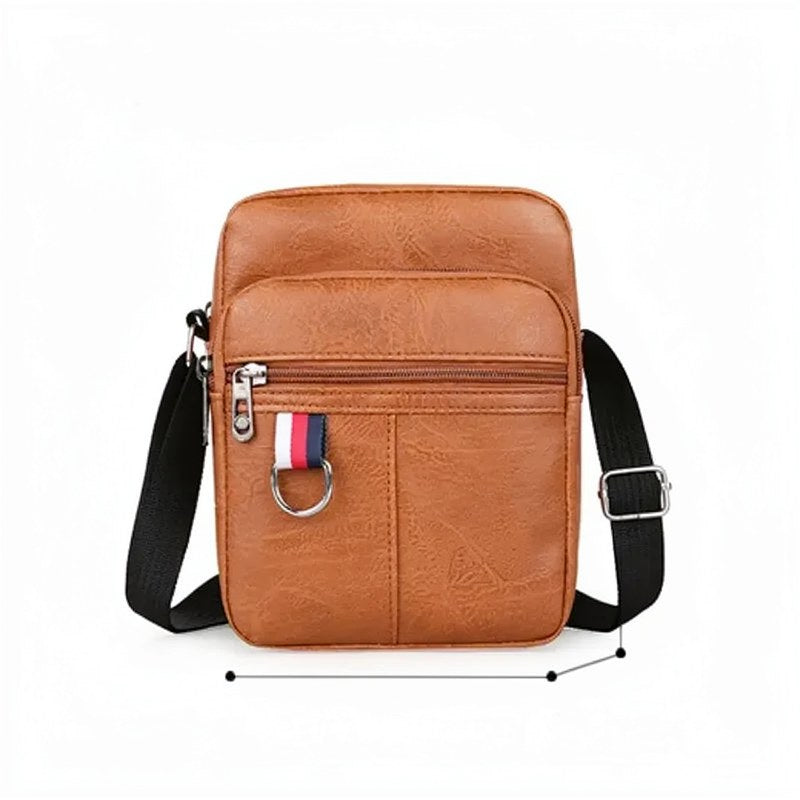 Sac bandoulière en cuir marron pour homme avec bretelle noire et quincaillerie argentée.