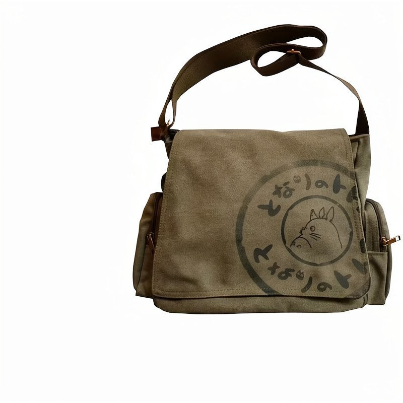 Bolso cruz de lona marrón con cierre de cremallera y diseño circular de la cara de un gato.