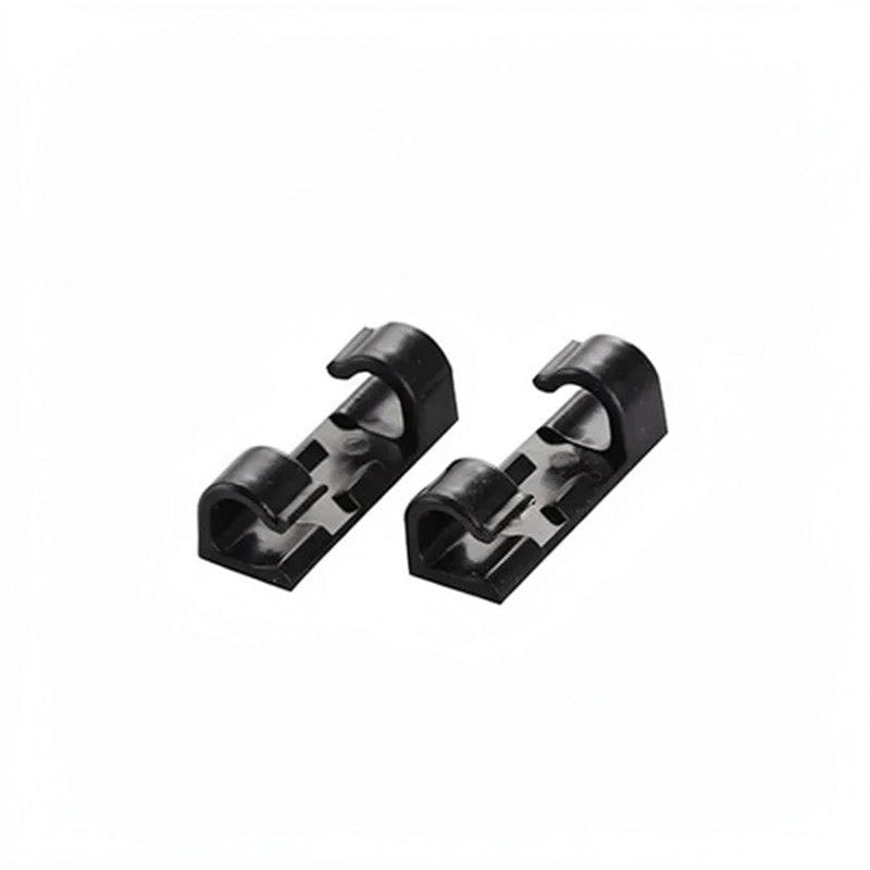 Two black desktop cable management clips shown diagonally.
