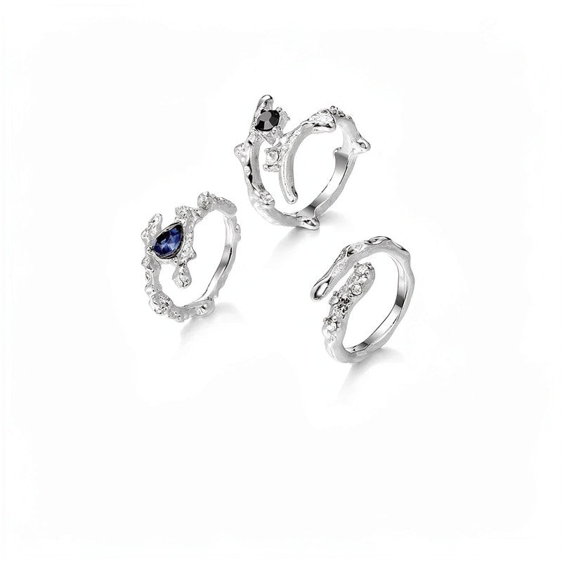 Silver irregular heart ring with small diamonds and a blue gemstone.