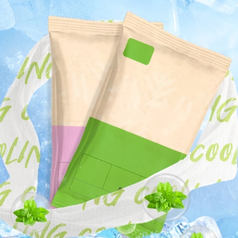 Paquet de serviette de refroidissement instantané à la menthe, avec un design jaune pâle et vert, entouré de feuilles de ment