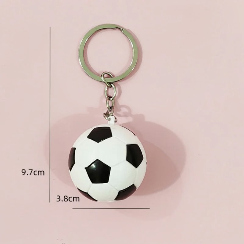 Charm de balón de fútbol blanco y negro en llavero metálico plateado.
