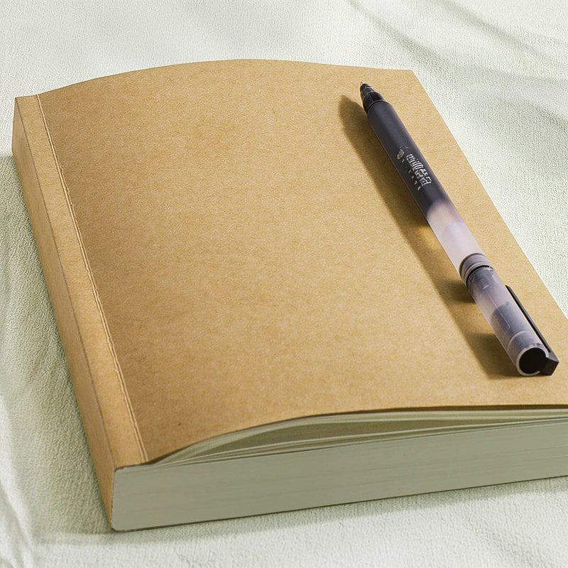 Braunes, minimalistisches Kuhfell-Notizbuch mit grünem Einband und schwarzem Stift oben.