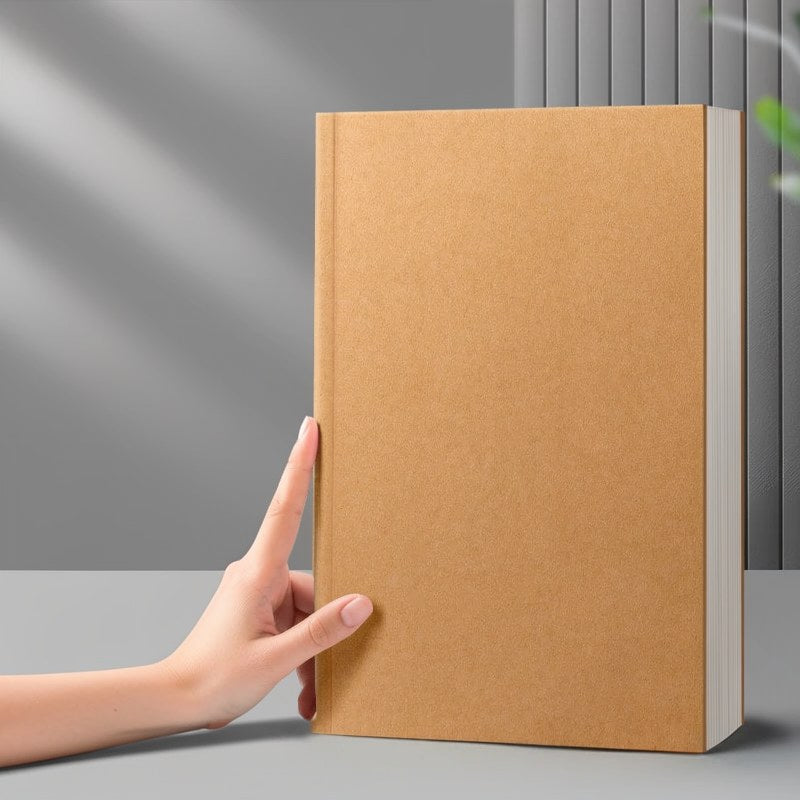 Eine Hand hält ein braunes, minimalistisches Kuhfell-Notizbuch mit hellem Einband vor grauem Hintergrund.