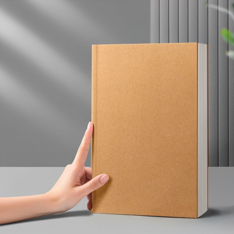 Eine Hand hält ein braunes, minimalistisches Kuhfell-Notizbuch auf einer grauen Oberfläche.