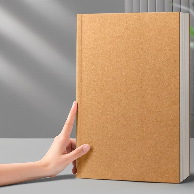 Ein braunes, minimalistisches Kuhfell-Notizbuch wird von einer Hand auf einer grauen Oberfläche gehalten.