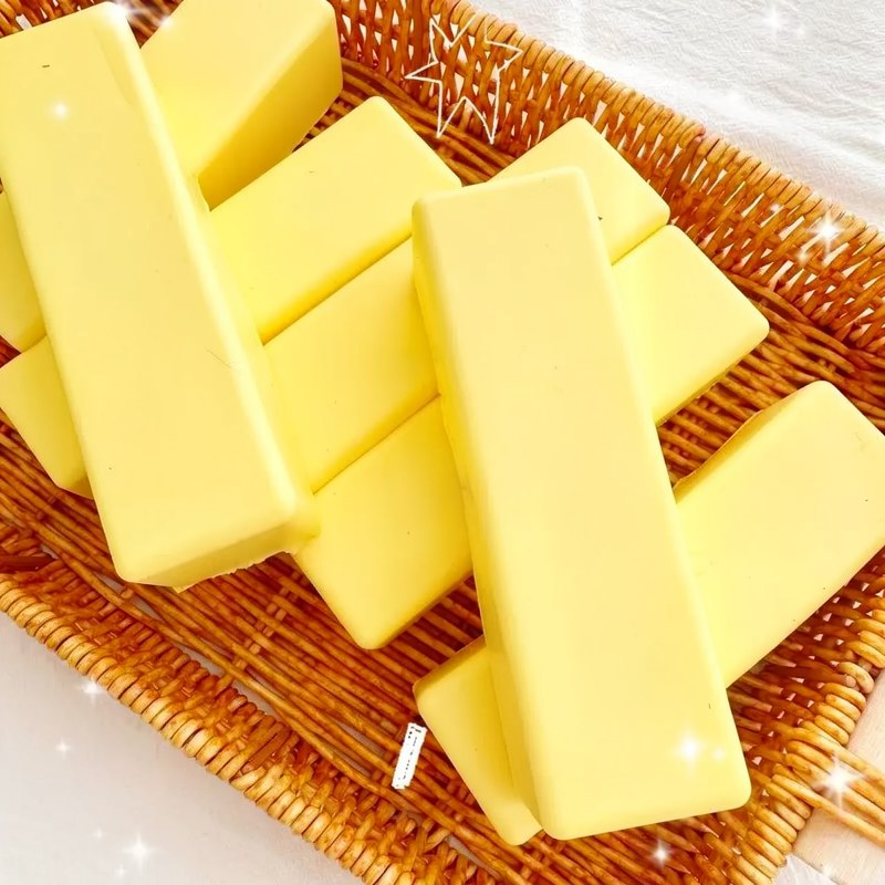 Yellow rainbow fidget sticks arranged in a woven basket on a white surface.