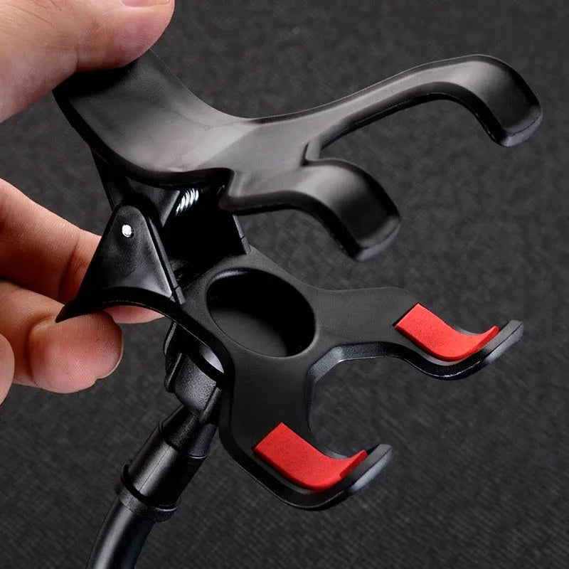 Support de téléphone universel noir avec ventouse et accents rouges tenu par la main.