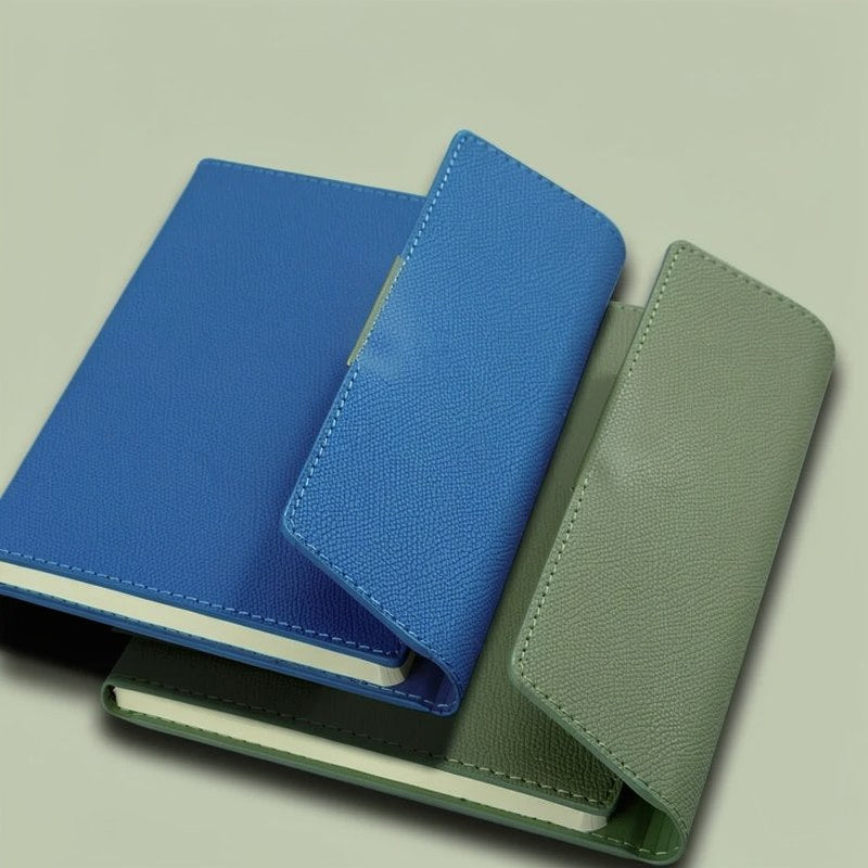 A stack of three A5 retro PU leather journal notebooks in blue, green, and olive colors.