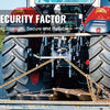 A close-up of heavy-duty transport binder chains with clevis hooks mounted on a tractor tire.